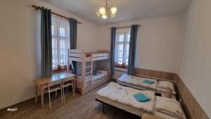 a room with two beds and a table and a desk at Ośrodek Wypoczynkowy Radosno in Sokołowsko +115 photos