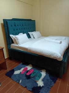 a bed with two pairs of slippers on a rug at Luxurious 2bedroom furnished apartment in Nairobi