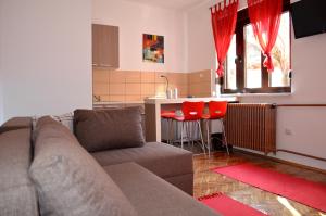 a living room with a couch and a kitchen at Apartmants Night Lux in Niš