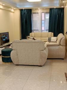 a living room with two couches and a tv at Luxurious 2bedroom furnished apartment in Nairobi