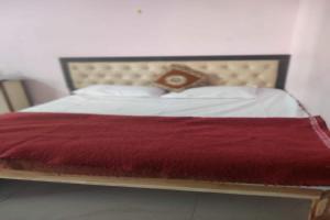 a bedroom with a bed with a red blanket at SPOT ON Sunrise Inn in Dhantoli