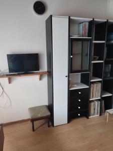 a living room with a tv and a book shelf at LHMNIA GH in Néa Koútali