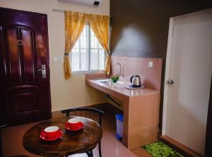 a small kitchen with a table and a sink at Lea's Guesthouse and Restaurant in Phumĭ Phlov Phnum Pénh