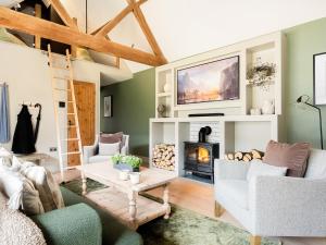 a living room with green walls and a fireplace at Lantern Lodge in Bramley