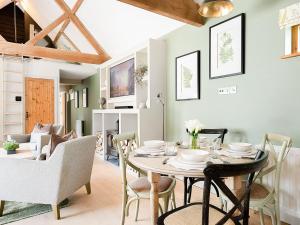 uma sala de jantar com mesa e cadeiras em Lantern Lodge em Bramley