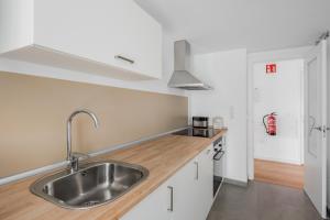 une cuisine avec un évier en acier inoxydable et un plan de travail en bois dans l'établissement Lopimar Bonito, à Canet d'En Berenguer