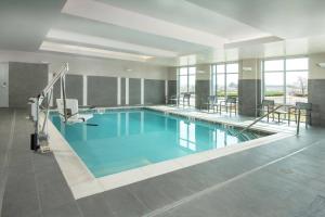 a large swimming pool with blue water in a building at Residence Inn Fulton at Maple Lawn in Fulton