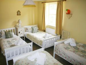 a room with three beds and a window at Carrot Cottage - Uk32609 in Manton