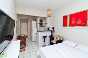 1 dormitorio con 1 cama blanca y cocina en Studio barato perto de Ipanema, en Río de Janeiro