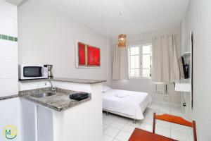 eine Küche mit einem Waschbecken und ein Bett in einem Zimmer in der Unterkunft Studio barato perto de Ipanema in Rio de Janeiro