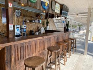 a bar with a row of wooden stools at BAYMARINAログハウス in Sakaide