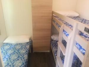 um pequeno quarto com 2 beliches e uma escada em Camping Covadonga em Soto de Cangas