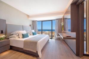 a bedroom with a bed and a desk with a view at Amathus Beach Hotel Limassol in Limassol