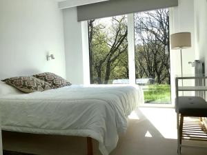 a bedroom with a bed and a large window at Villa El Rodal in Pontones