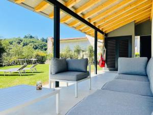 a patio with a couch and a chair and a table at Villa El Rodal in Pontones