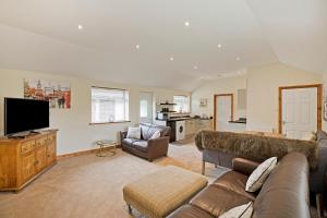 a living room with a couch and a flat screen tv at Plum Cottage in Knaresborough
