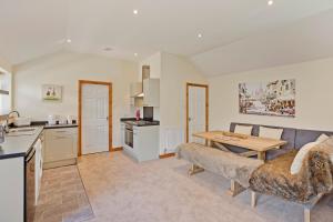 a kitchen and living room with a couch and a table at Plum Cottage in Knaresborough