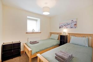 a bedroom with two beds and a window at Plum Cottage in Knaresborough