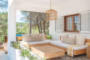 un patio con 2 sofás y una mesa en Casa Can Vert con piscina en Santa Gertrudis de Fruitera