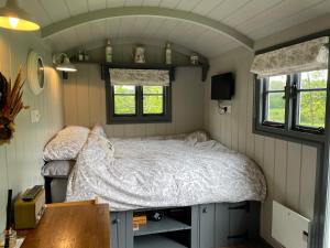 a bedroom with a bed in a tiny house at Greatwood Shepherds Hut in Battle