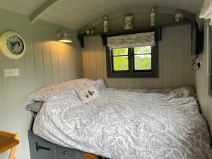 een slaapkamer met een bed in een kleine kamer bij Greatwood Shepherds Hut in Battle