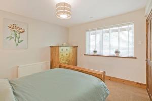 a bedroom with a bed and a window at Port Arthur Cottage in Knaresborough