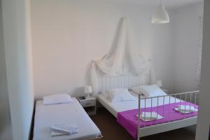 a bedroom with two beds with pink and white sheets at Apartment Vlado in Sukošan