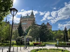 ein Schloss in einem Park mit Straßenbeleuchtung in der Unterkunft Rose Cottage in Prievidza