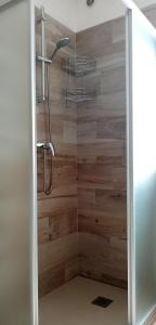 uma casa de banho com um chuveiro e uma parede de madeira em Al Portec em Vezzano