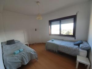 a bedroom with two beds and a window at Figueira Family Apartment in Figueira da Foz