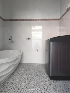 a white bathroom with a tub and a sink at Konex homestay in Canggu