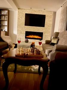 uma sala de estar com um tabuleiro de xadrez e taças de vinho em Pensiunea Ivoire em Avrig