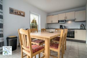 a kitchen with a wooden dining table and chairs at Wald und See Dargun 16A in Dargun
