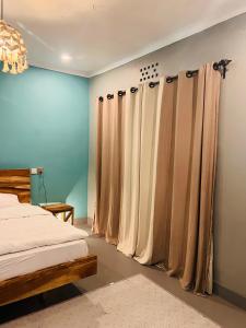 a bedroom with a bed and curtains in it at City Retreat Arusha in Arusha
