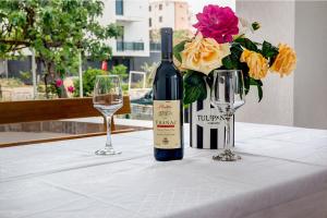 a bottle of wine and glasses on a table with flowers at Holiday Home Adria in Dobra Voda