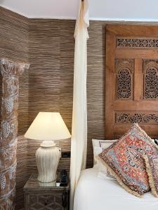 a bed with a wooden headboard and a table with a lamp at Royal Garden Villas, Luxury Hotel in Adeje