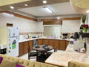 a kitchen with a table and a refrigerator at Jasmine's House in Jerash