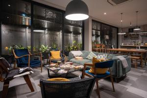 a living room with chairs and a couch and a table at humble abode Bangkok Vacation Home in Bangkok