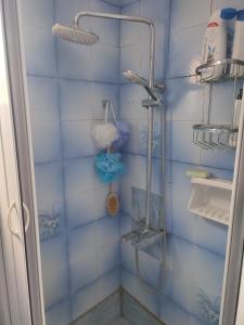 ein Bad mit einer Dusche und blauen Fliesen in der Unterkunft LHMNIA GH in Néa Koútali