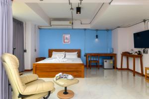 um quarto com paredes azuis e uma cama e uma cadeira em Na BaanYa Chiang Mai em Chiang Mai