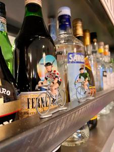 a shelf with bottles of alcohol and figurines of people riding bikes at Casa Conte Rosso in Avigliana