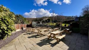a group of wooden picnic tables on a patio at Hafan Artro in Llanbedr +83 photos