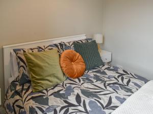 a bed with pillows and a orange ball on it at Russell Retreat in Skipton