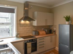 a kitchen with a stove and a refrigerator at Russell Retreat in Skipton