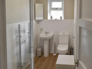 a white bathroom with a toilet and a sink at Russell Retreat in Skipton