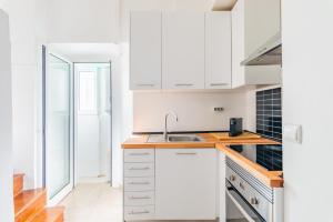 a kitchen with white cabinets and a sink at Casa de Santana in Lisbon