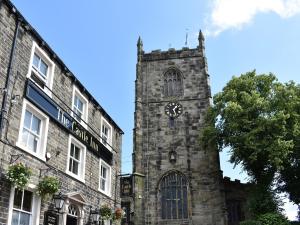 a building with a clock tower in front of a building at Russell Retreat in Skipton