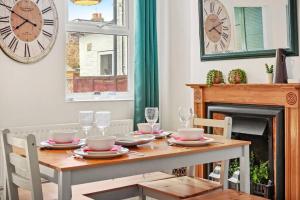 Aesthetic Cambridge Cottage sleeps 5! في كامبريدج: غرفة طعام مع طاولة وساعة على الحائط