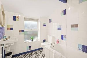 ein Badezimmer mit einer Badewanne, einem WC und einem Waschbecken in der Unterkunft Aesthetic Cambridge Cottage sleeps 5! in Cambridge