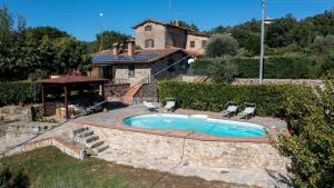 a swimming pool with two chairs and a house at Podere La Casa in Cavriglia